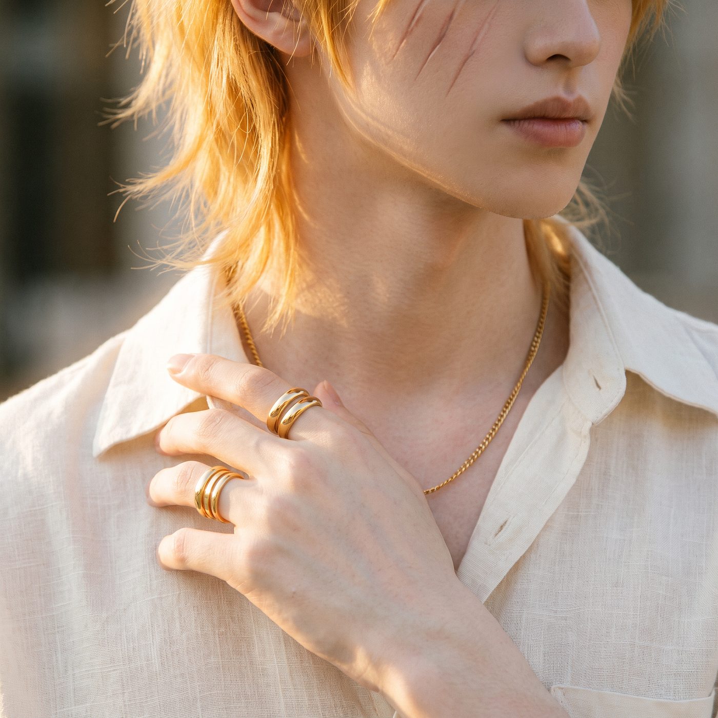 Close-up of hands with gold rings and fine chain